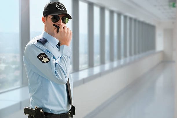 Security guard is talking with walkie talkie . Security guard is talking with walkie talkie .